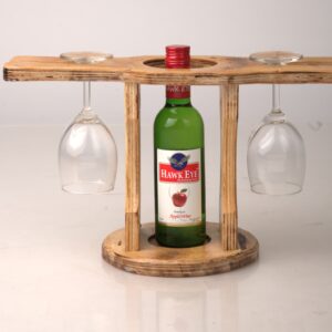 A handcrafted wooden wine stand holding a green wine bottle in the center and two upside-down wine glasses on the side arms.