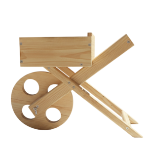 Decorative wooden wheelbarrow planter with green succulents in a sunlit garden setting with brick background.